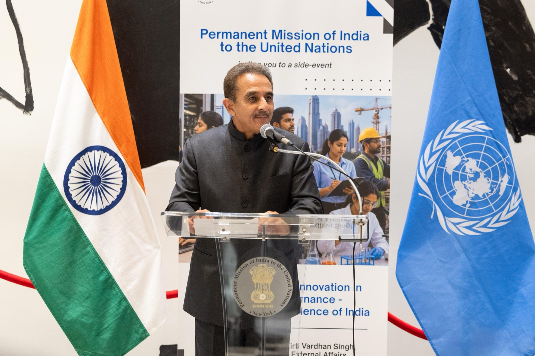 Kirtivardhan Singh speaking at a lectern between the flags of India and the United Nations